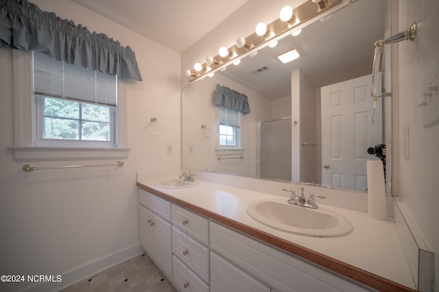 full bathroom with visible vents, a sink, a shower with shower door, and baseboards