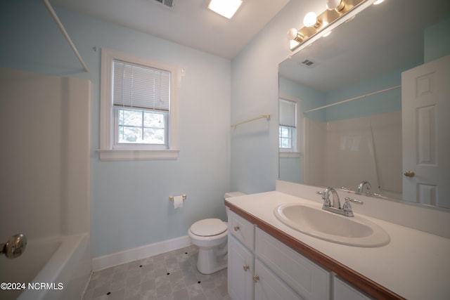 bathroom featuring a healthy amount of sunlight, toilet, vanity, and baseboards