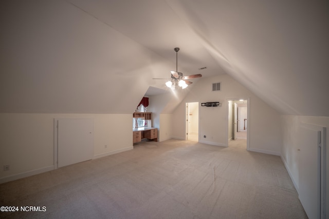 additional living space featuring ceiling fan, baseboards, vaulted ceiling, and light colored carpet