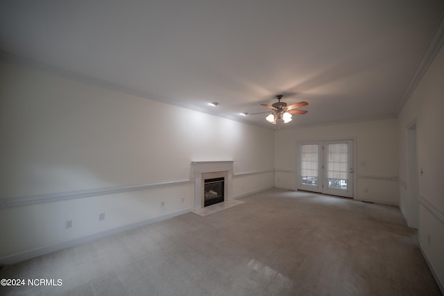 unfurnished living room with light carpet, ceiling fan, a glass covered fireplace, and crown molding