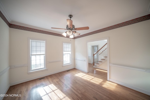 unfurnished room with baseboards, visible vents, light wood-style flooring, stairs, and crown molding