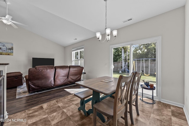 dining space with lofted ceiling, ceiling fan with notable chandelier, and a wealth of natural light