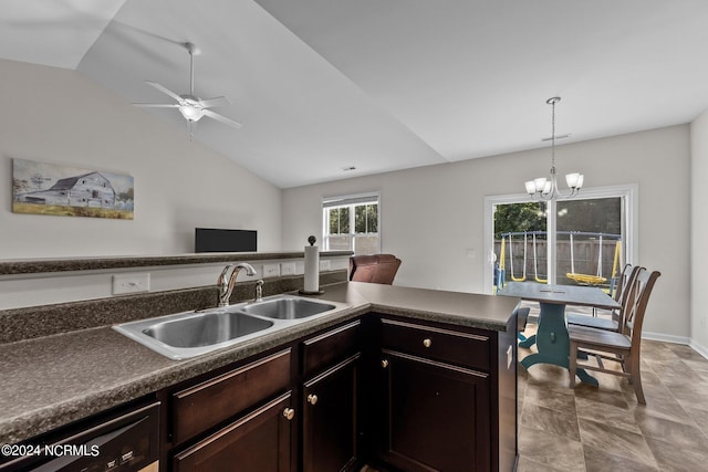 kitchen featuring lofted ceiling, sink, pendant lighting, dark brown cabinets, and ceiling fan with notable chandelier