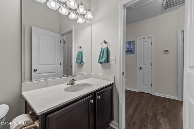 bathroom with vanity, wood-type flooring, and toilet