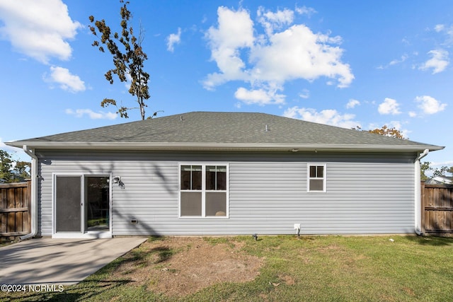 rear view of property with a lawn and a patio