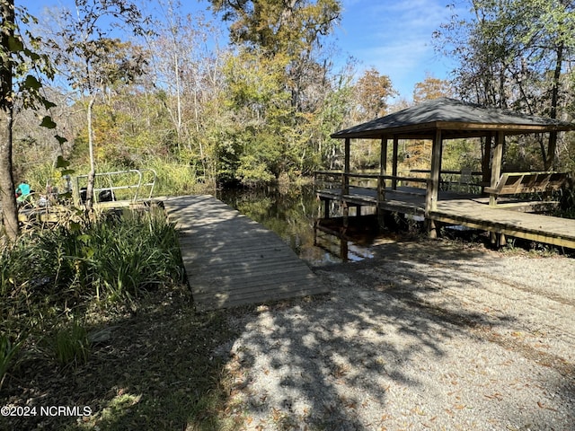 view of dock with a gazebo and a water view