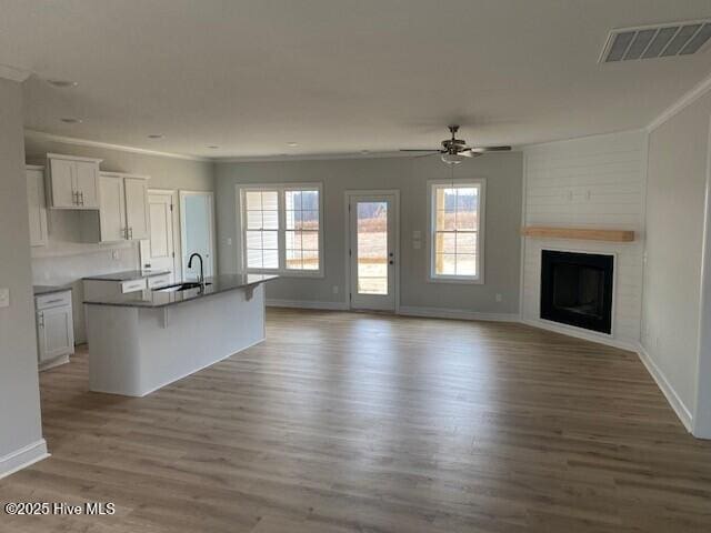 kitchen with white cabinetry, a breakfast bar, a center island with sink, and a wealth of natural light