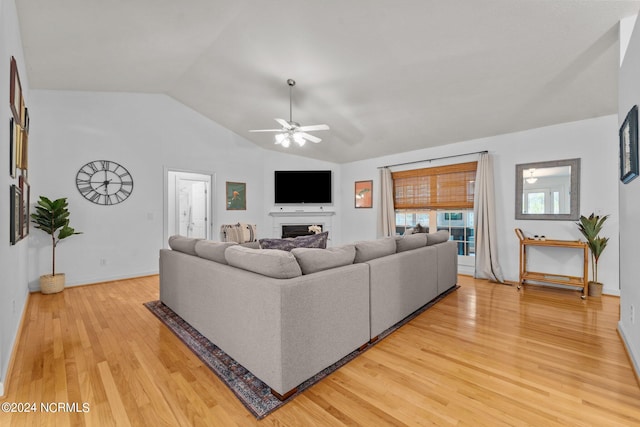 living room with ceiling fan, wood-type flooring, and lofted ceiling