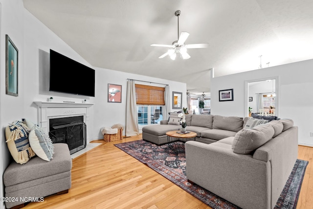 living room with ceiling fan, hardwood / wood-style flooring, and vaulted ceiling