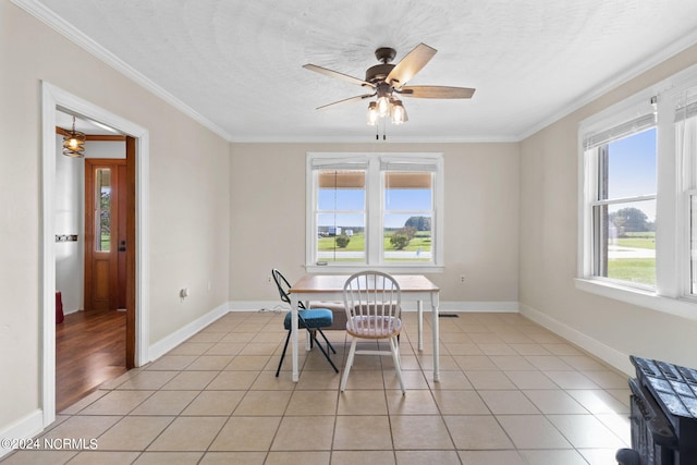 dining space featuring crown molding, light tile patterned floors, and a healthy amount of sunlight