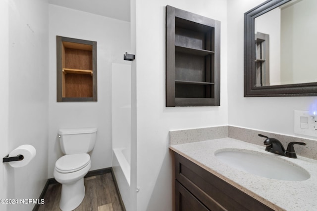 bathroom featuring vanity, wood-type flooring, and toilet