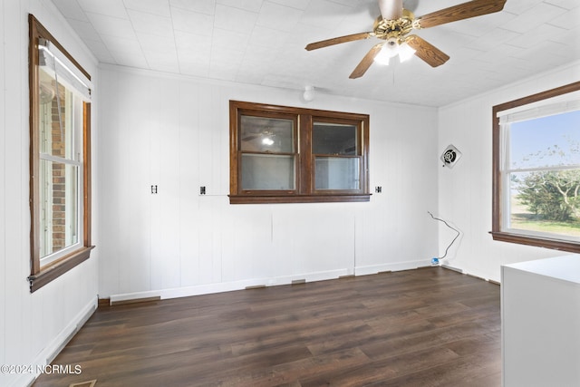 unfurnished room with ceiling fan, crown molding, and dark wood-type flooring