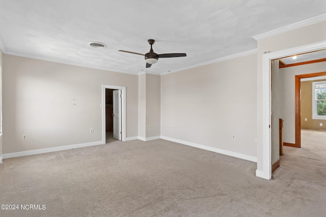 carpeted empty room with ceiling fan and ornamental molding