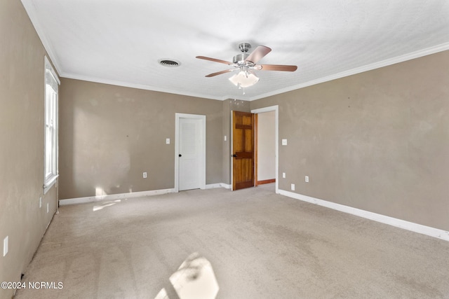 carpeted spare room with ceiling fan and ornamental molding