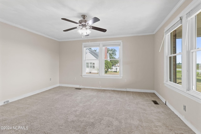 unfurnished room featuring carpet, ceiling fan, crown molding, and a wealth of natural light