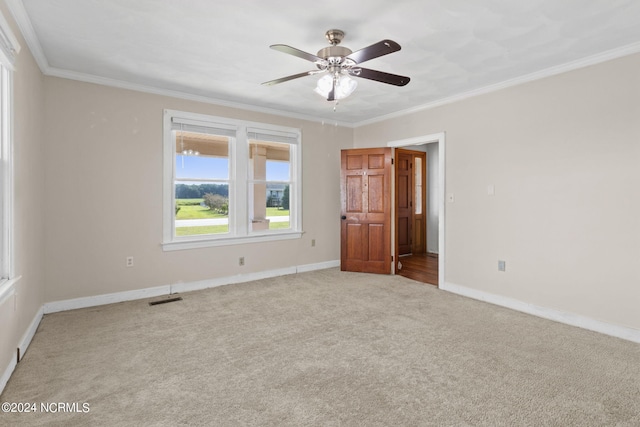 carpeted empty room with ceiling fan and crown molding