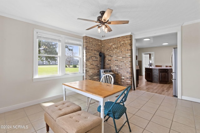 dining room featuring light tile patterned floors, crown molding, and a wood stove