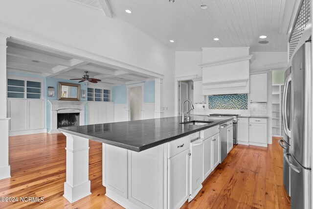 kitchen featuring a premium fireplace, a kitchen island with sink, sink, ceiling fan, and white cabinets