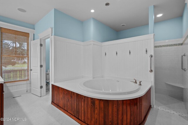 bathroom featuring tile patterned flooring and shower with separate bathtub