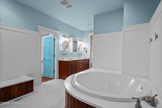 bathroom with tile patterned flooring, vanity, and a bathing tub