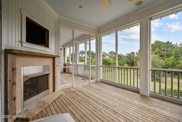 unfurnished sunroom featuring ceiling fan