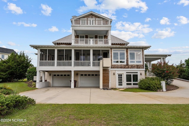 view of front of property with a balcony, a garage, and a front lawn