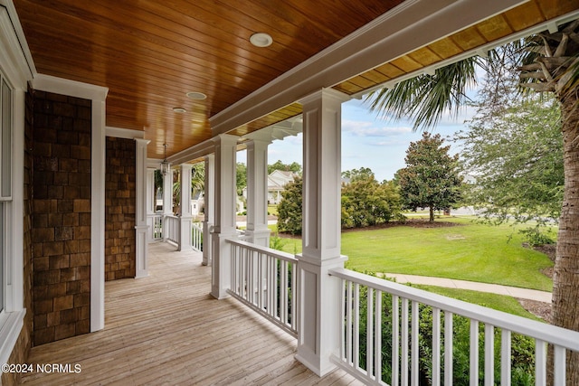 wooden deck featuring a lawn and covered porch