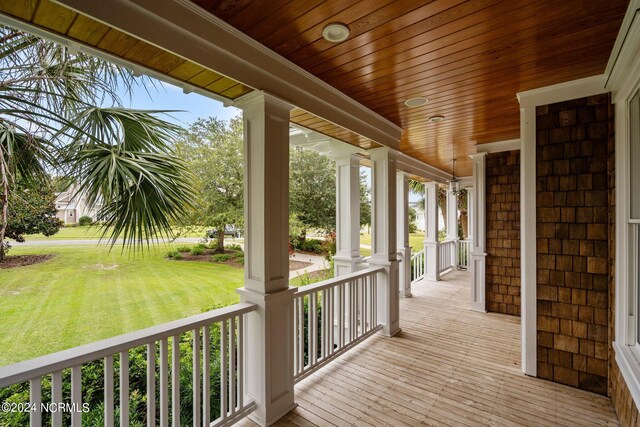 wooden deck featuring a lawn and covered porch