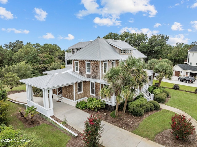 view of front of property featuring a garage, a front lawn, and a porch