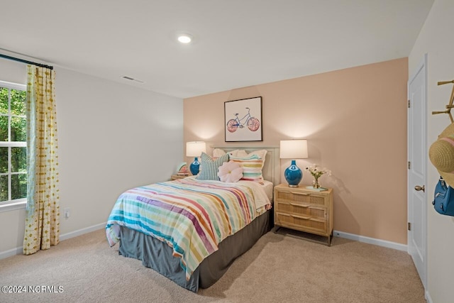 bedroom with light colored carpet and multiple windows