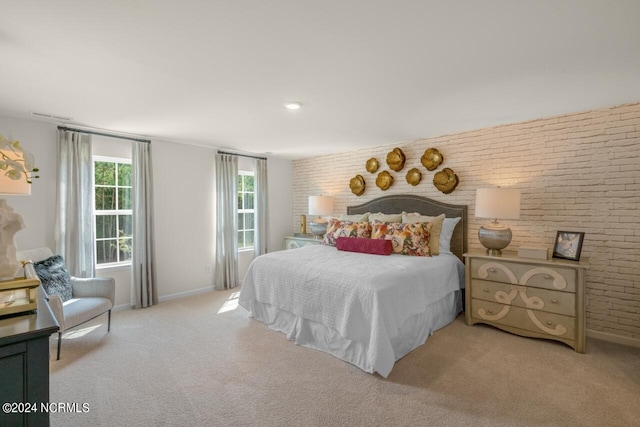 carpeted bedroom featuring brick wall