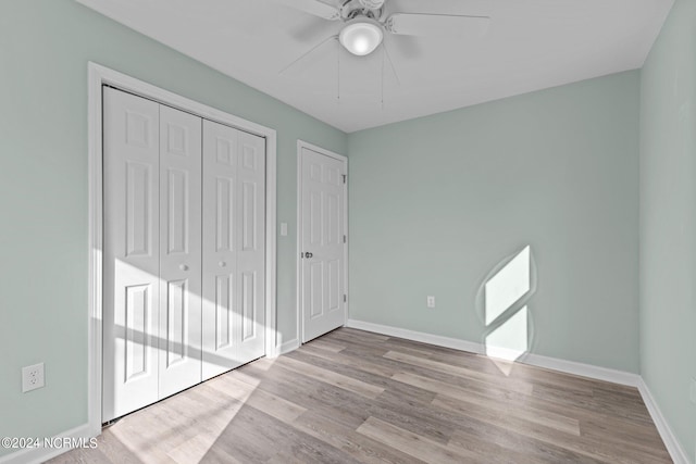 unfurnished bedroom with light hardwood / wood-style floors, ceiling fan, and a closet