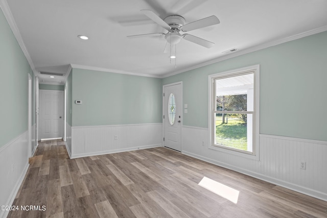 spare room featuring light hardwood / wood-style floors, ceiling fan, and crown molding