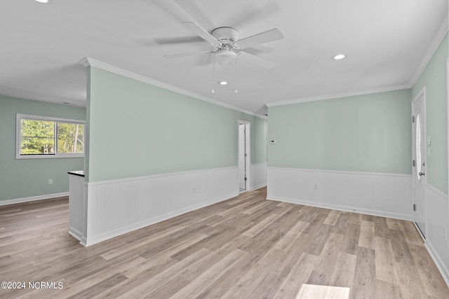 spare room featuring light wood-type flooring, crown molding, and ceiling fan