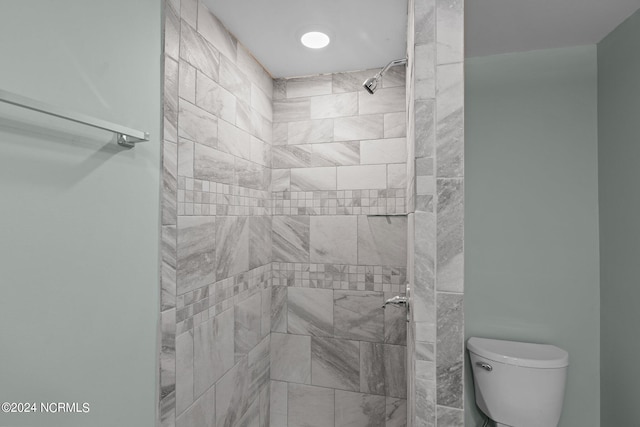 bathroom featuring toilet and a tile shower