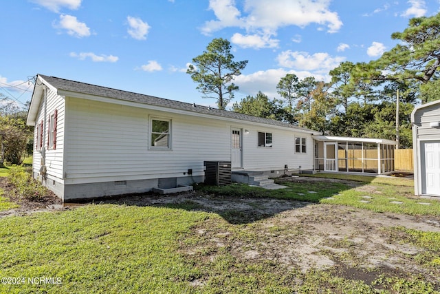 back of property featuring a lawn, central AC, and a sunroom