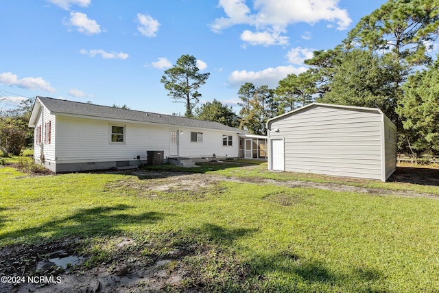 rear view of property featuring a lawn and central AC unit