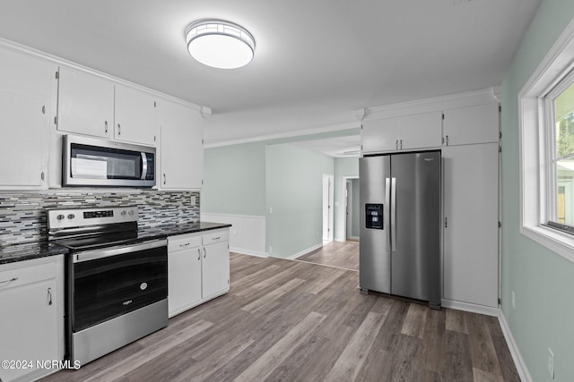 kitchen with appliances with stainless steel finishes, tasteful backsplash, light hardwood / wood-style flooring, and white cabinets