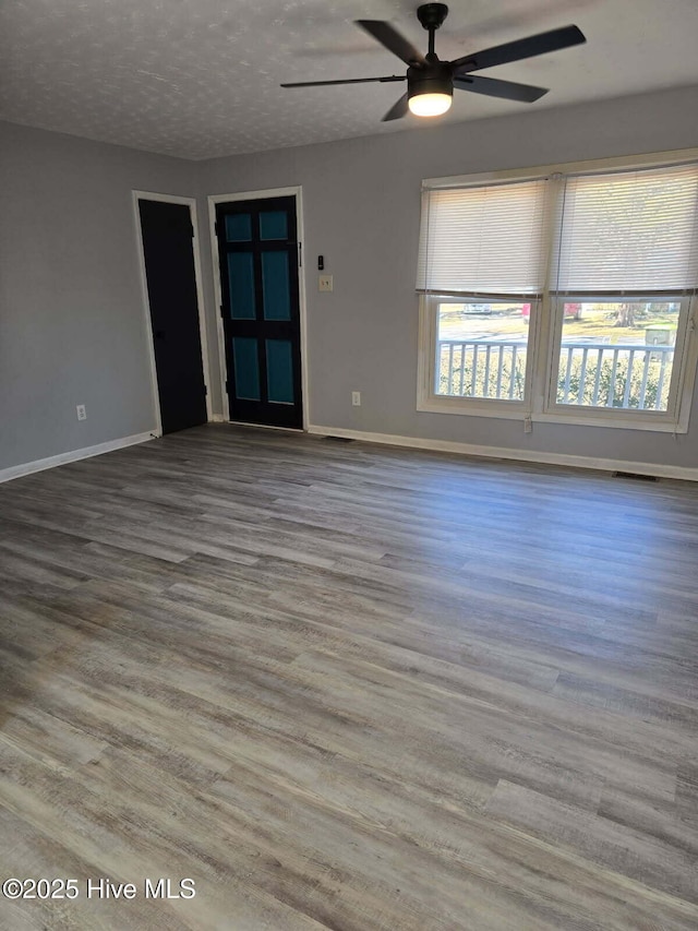 unfurnished room with ceiling fan, hardwood / wood-style floors, and a textured ceiling