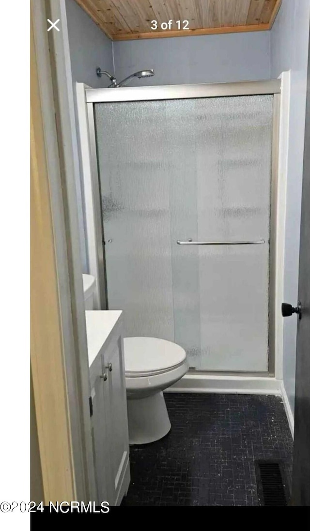 bathroom featuring vanity, wood ceiling, a shower with door, and toilet