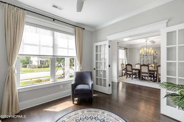 living area with ornamental molding, ceiling fan with notable chandelier, and dark hardwood / wood-style floors