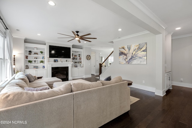 living room with ornamental molding, built in shelves, ceiling fan, and hardwood / wood-style flooring