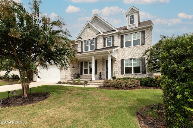 craftsman-style house featuring a garage, covered porch, and a front yard