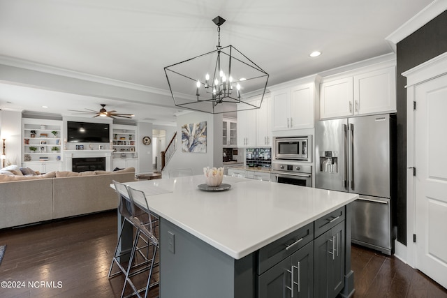 kitchen featuring white cabinets, ceiling fan with notable chandelier, a kitchen island, stainless steel appliances, and dark hardwood / wood-style floors