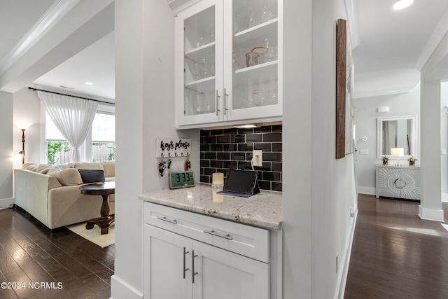 interior space with decorative backsplash, white cabinetry, light stone countertops, and dark wood-type flooring