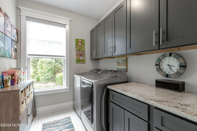 laundry area featuring cabinets, light tile patterned flooring, and washer and dryer