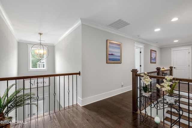 hallway featuring ornamental molding, dark hardwood / wood-style floors, and an inviting chandelier