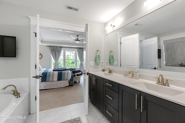 bathroom featuring ceiling fan, vanity, and tiled bath