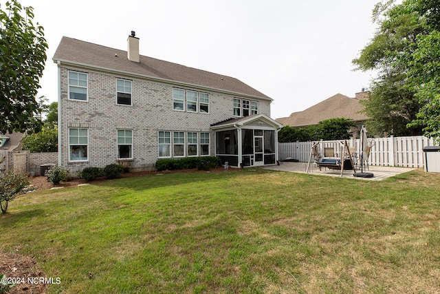 back of property with a sunroom, a patio, and a yard