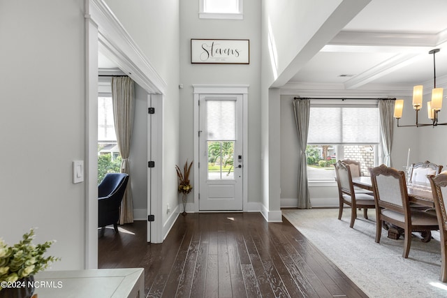 entrance foyer featuring beam ceiling, dark hardwood / wood-style flooring, and a notable chandelier